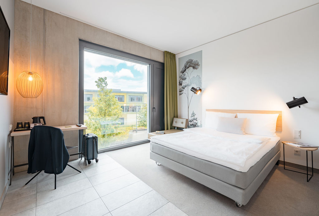 Guest room with a double bed and a floor-to-ceiling window