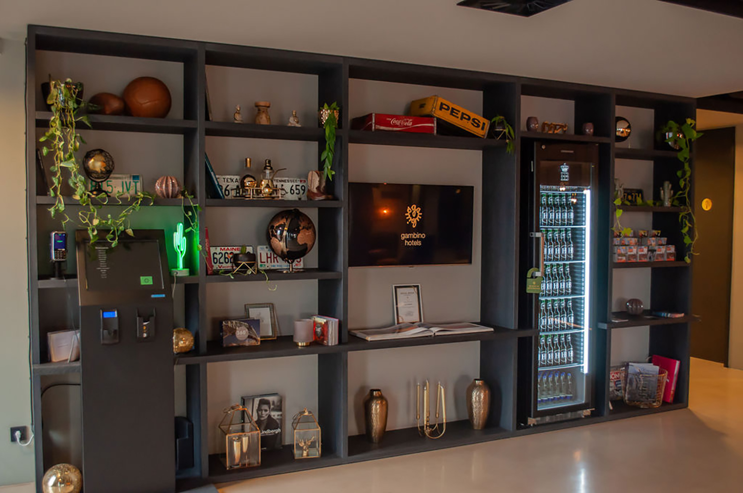 Lobby shelving with the self-check-in terminal and drinks fridge