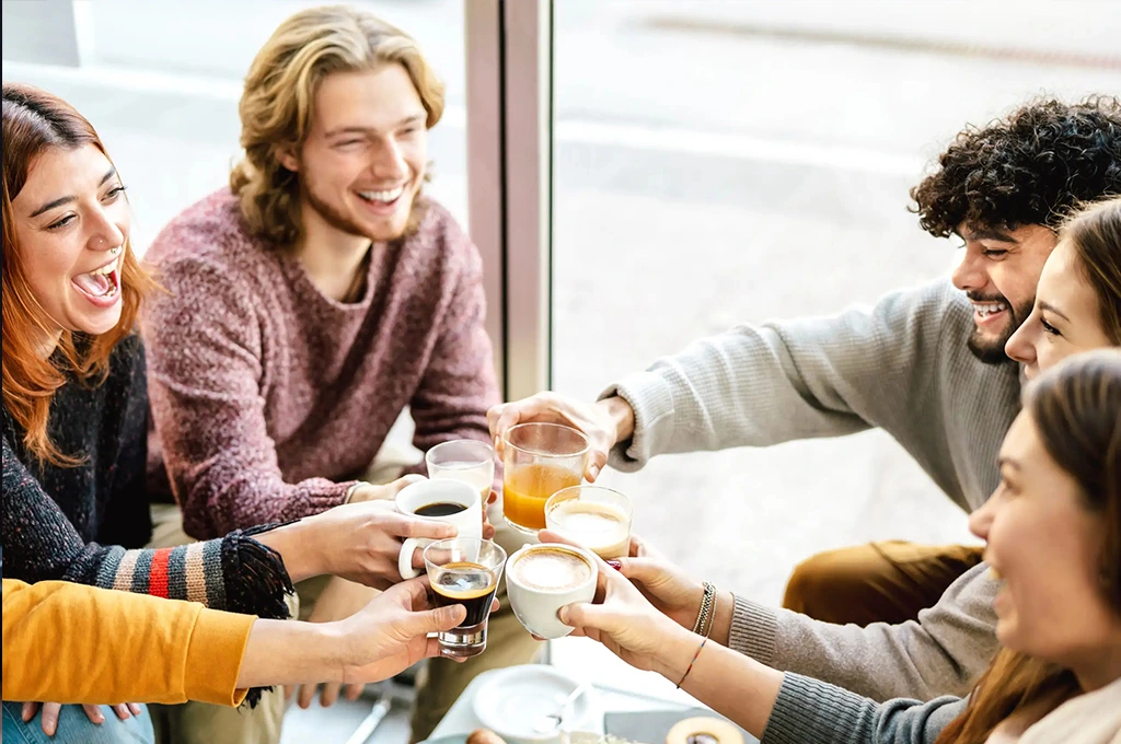Guests raising coffee cups together at a breakfast table